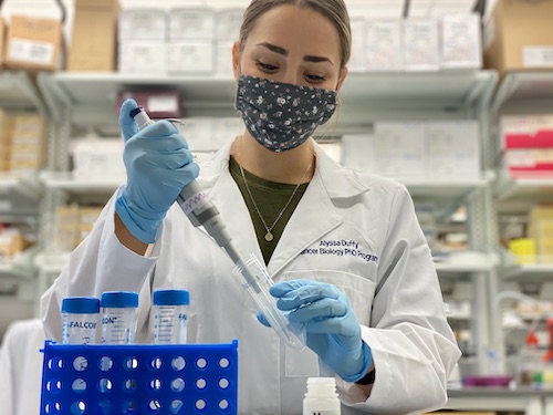 Woman in a lab filling test tubes